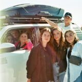 a group of people standing in front of a van