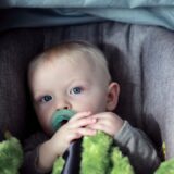 baby on gray stroller