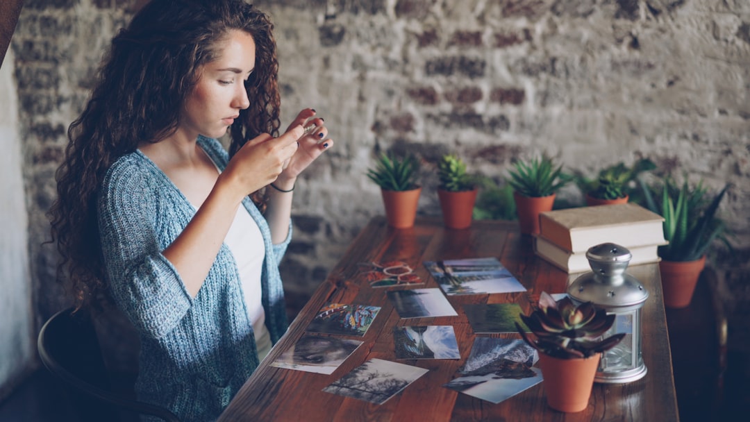 Woman looking at photos on her phone at a table.