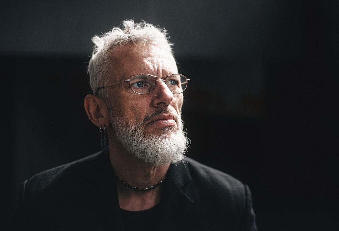 A thoughtful older man looks off into the distance.