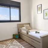 A child's bedroom with a twin bed and toys.