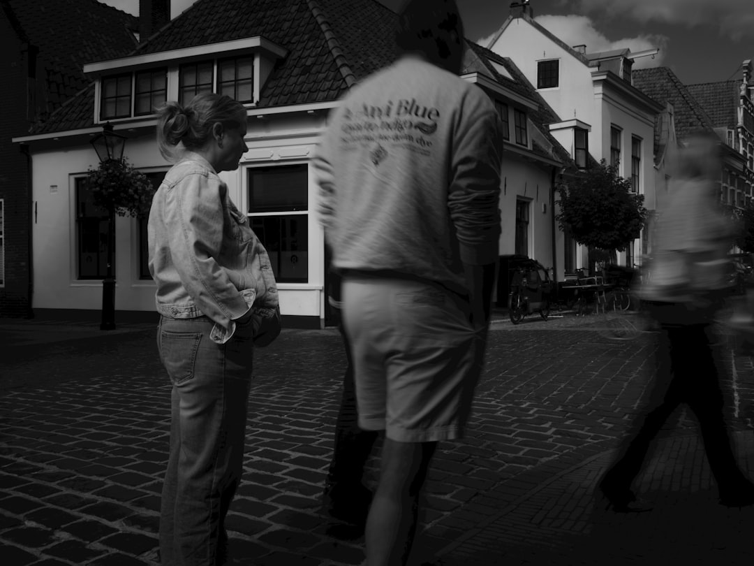 People walking on a cobblestone street in town.