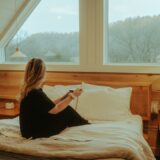 a woman sitting on a bed in a loft