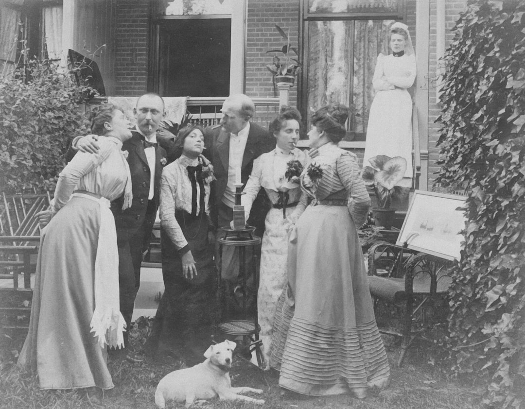 Group of people posing outside a house with a dog.