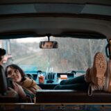 man sitting on bucket seat while woman on his lap