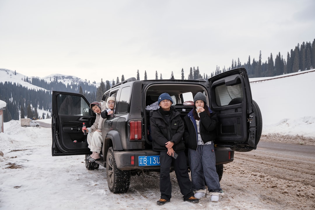 People gathered around a car in a snowy landscape.