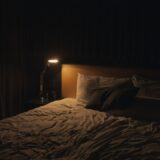 table lamp turned-on near bed