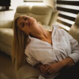 a woman laying on a couch in a living room