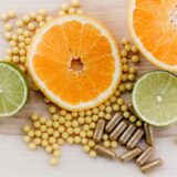 oranges, peas, and limes on a wooden table