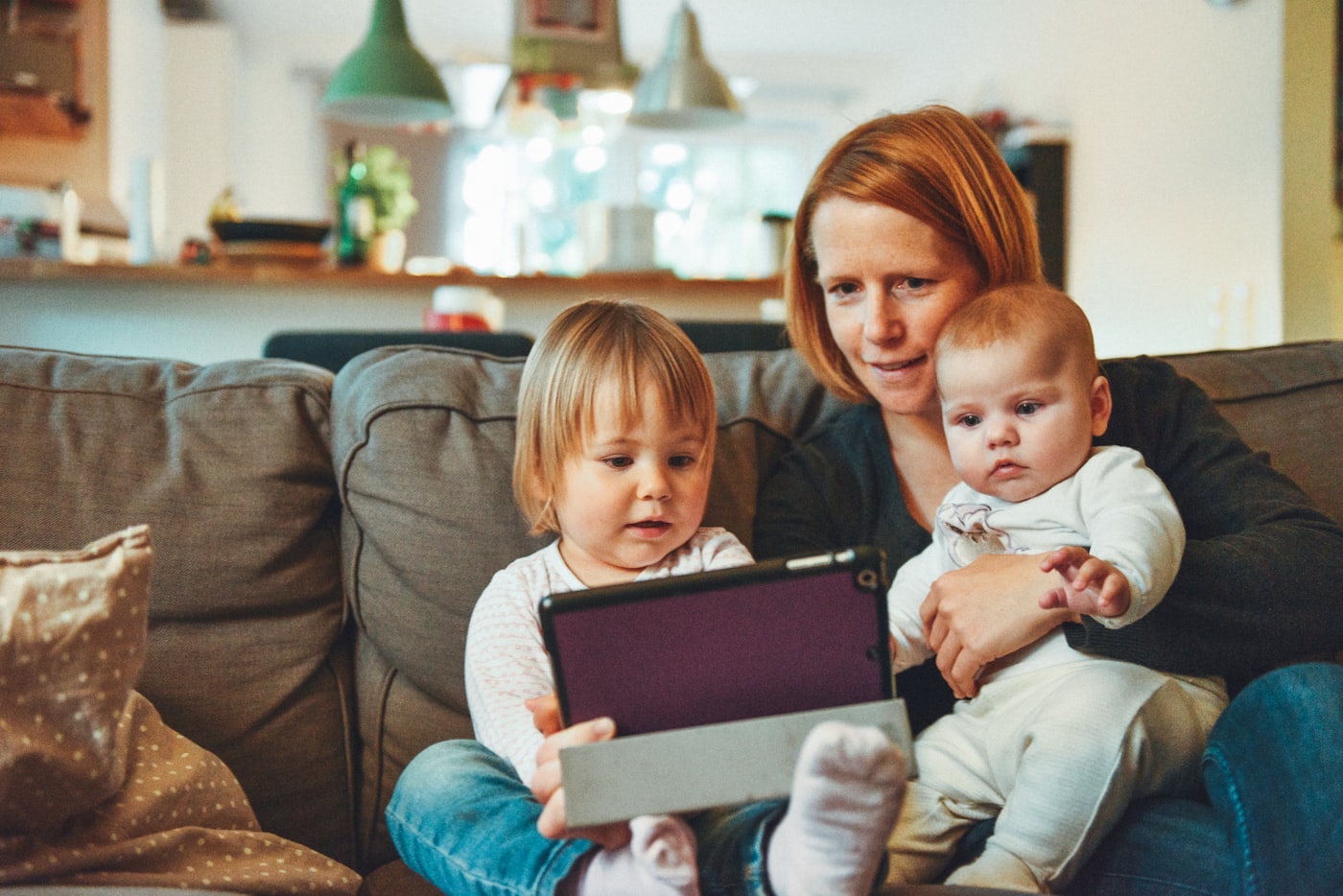 Ouder met kinderen samen op de bank