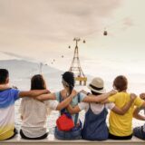 Vrienden zitten samen op een muurtje tijdens vakantie