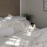 Opgemaakt bed met witte kussens in lichte slaapkamer