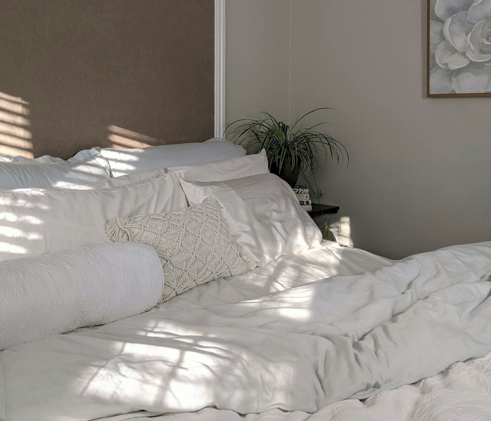 Opgemaakt bed met witte kussens in lichte slaapkamer