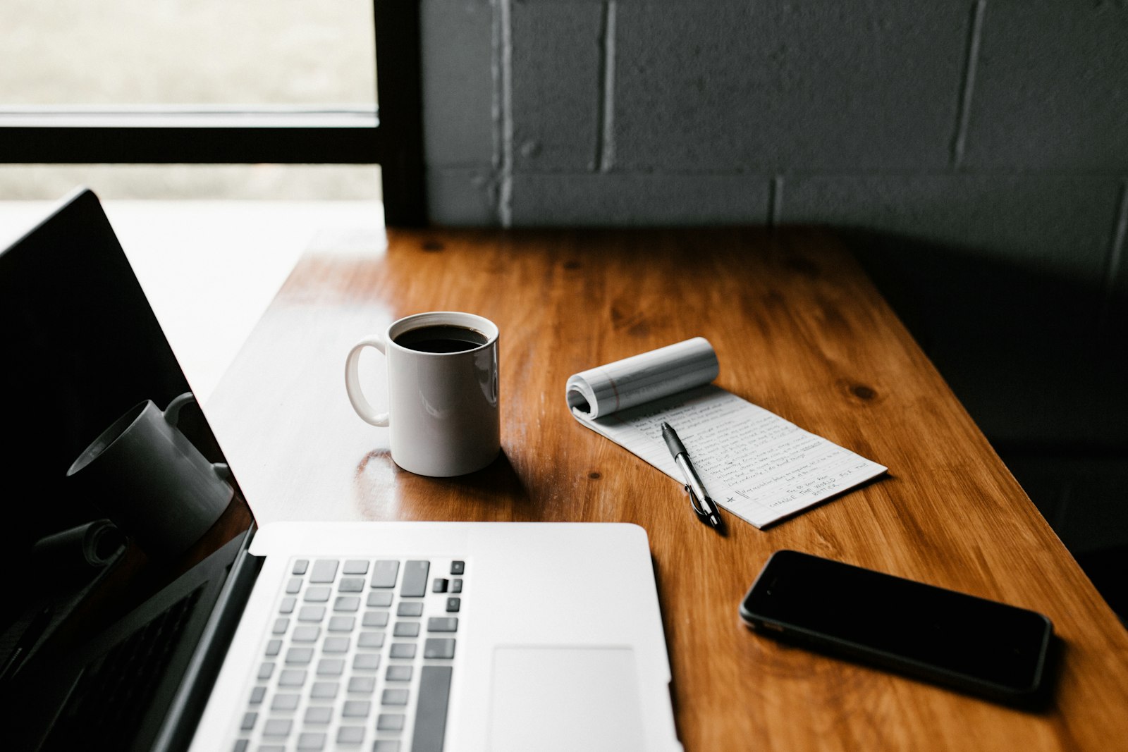 Laptop met koffie op een tafel, werken buiten de deur