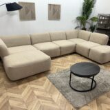 Beige bouclé hoekbank in een showroom