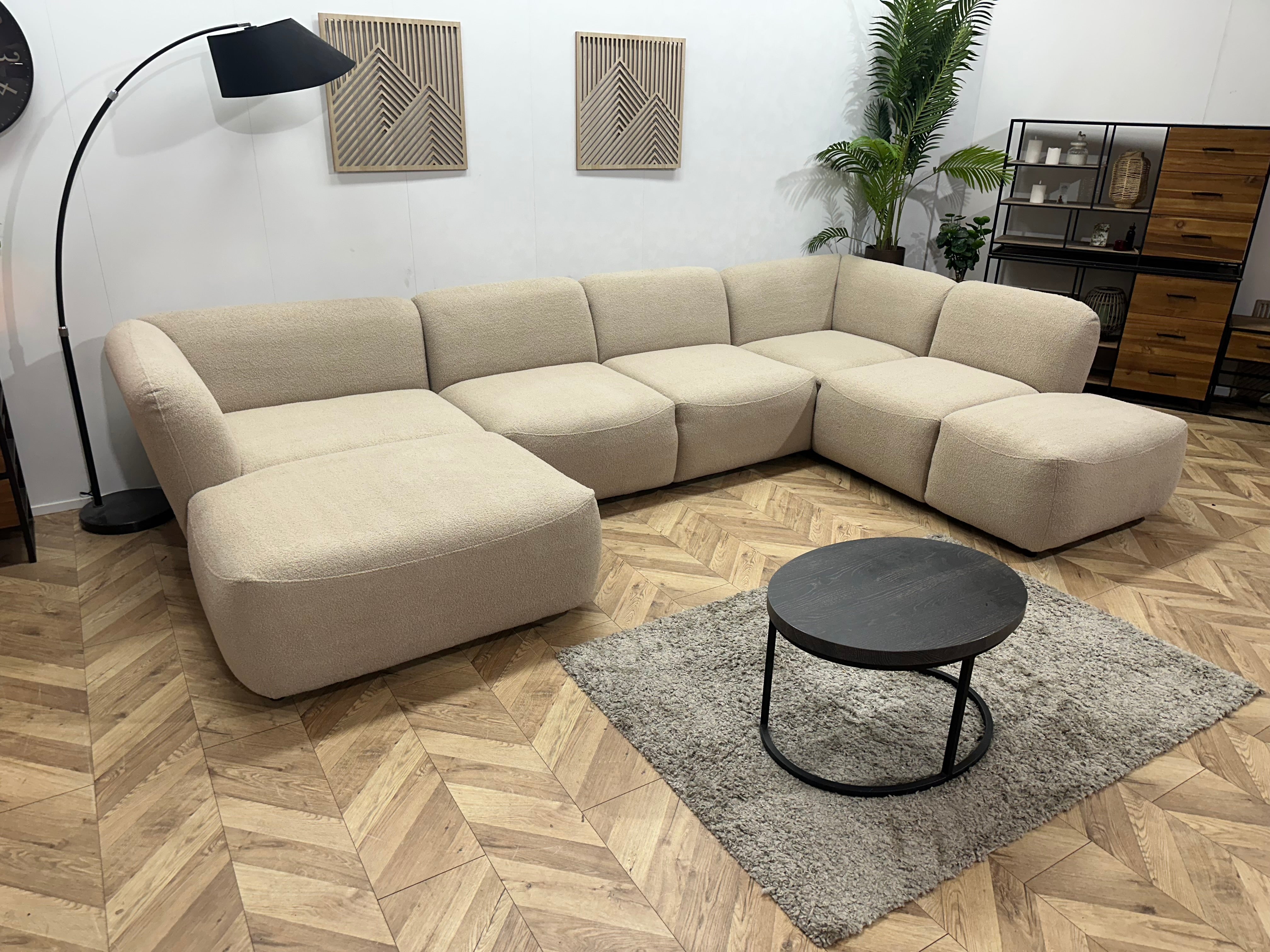 Beige bouclé hoekbank in een showroom