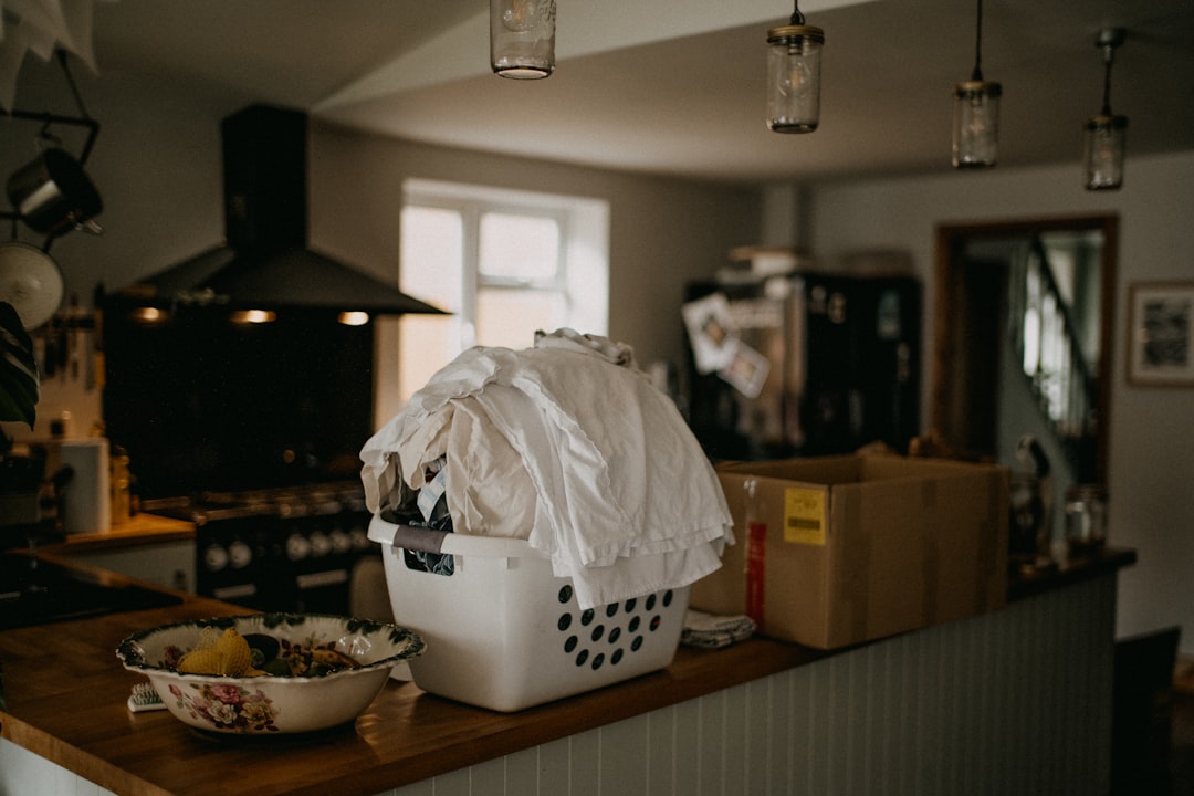 Witte wasmand met wasgoed op een houten aanrecht in een huiselijke keuken