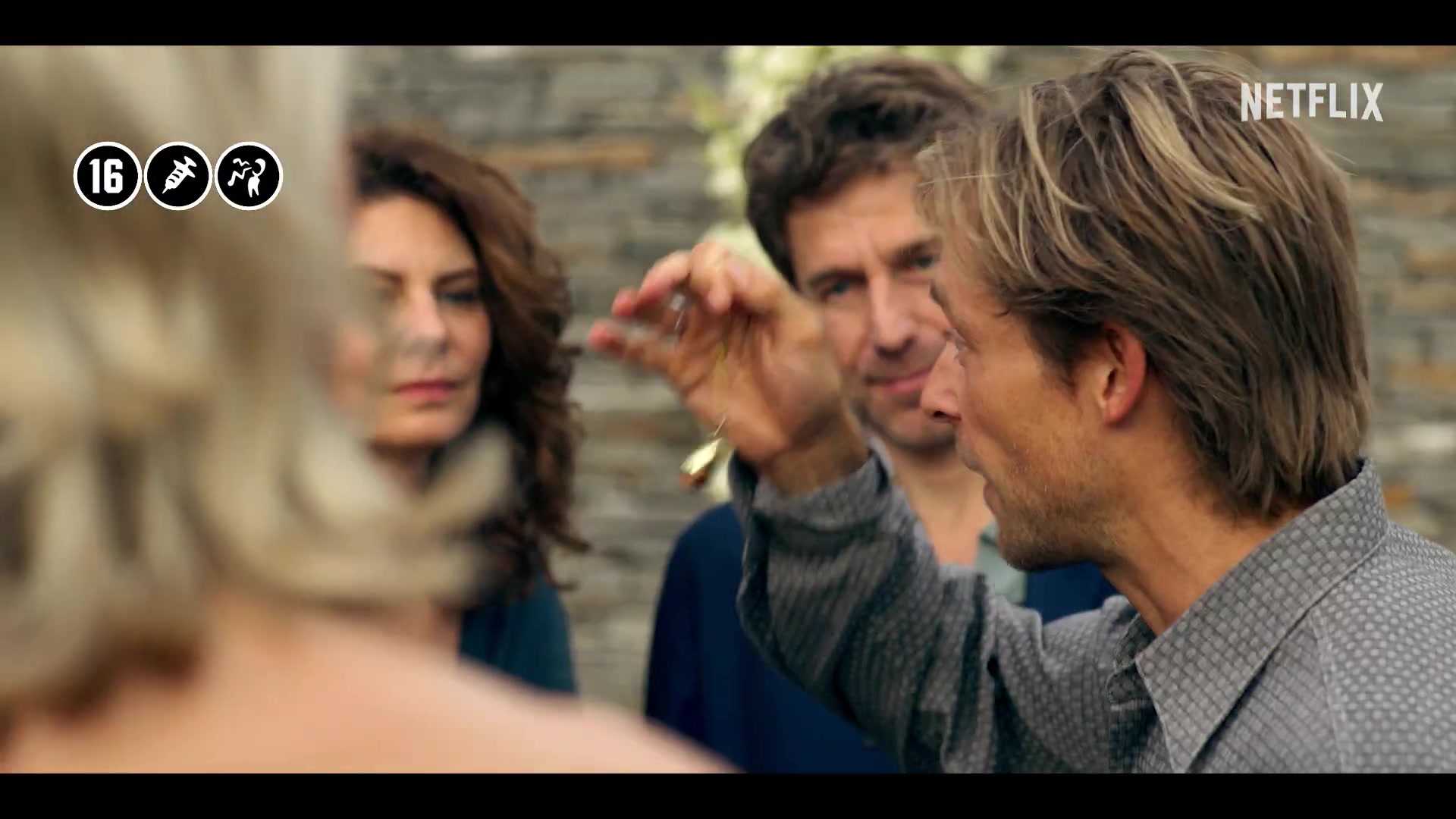 Leden van de eetclub rond een man die iets omhoog houdt in de officiële Netflix-trailer van De Eetclub