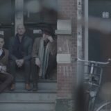 Douwe Bob met hoed op een stoep in Amsterdam in de videoclip van Slow Down