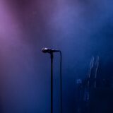 Gitaar en microfoon op een leeg podium voor aanvang van een concert