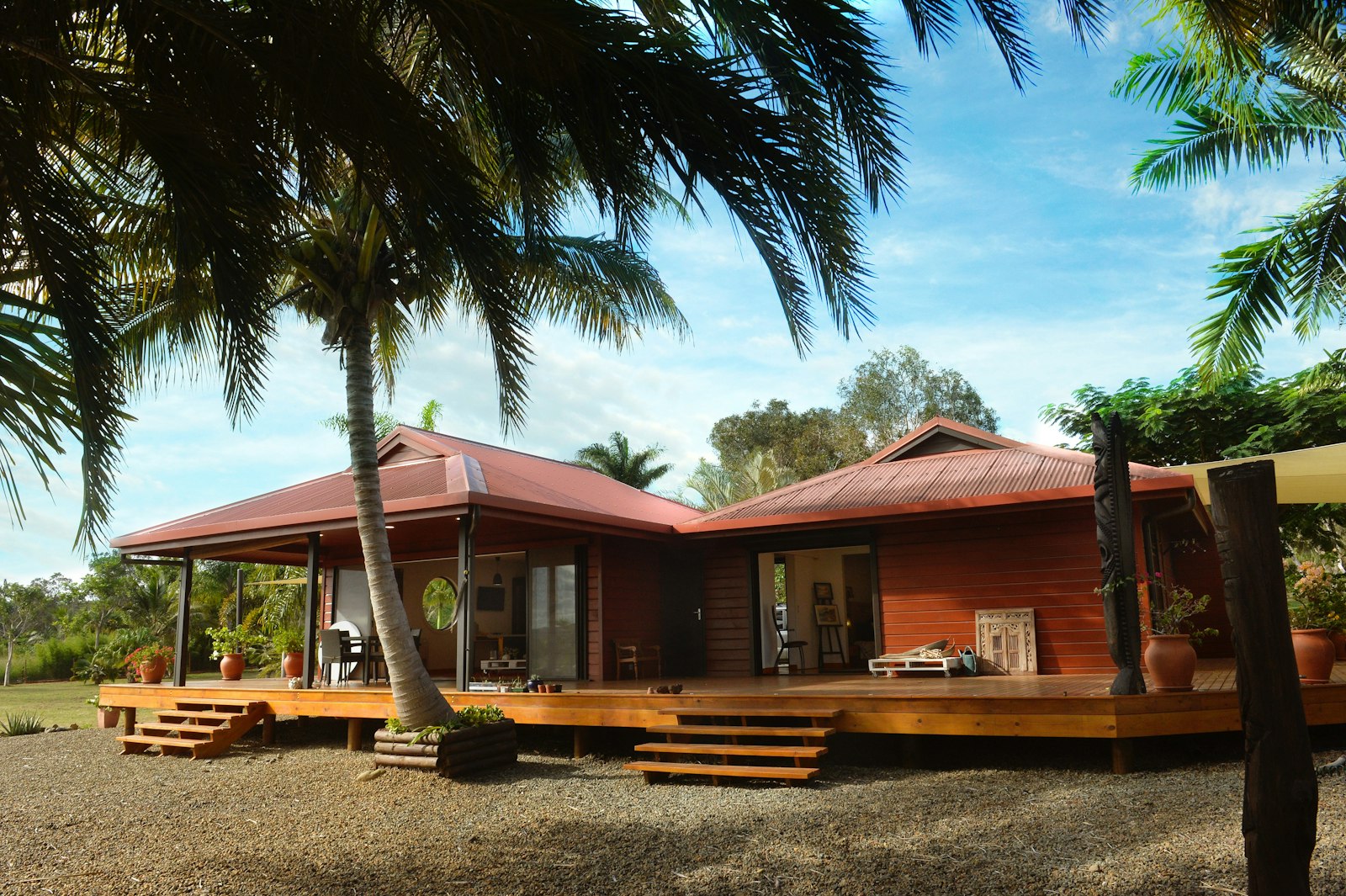 Terras van een bed and breakfast op een tropisch eiland met palmen en lege stoelen