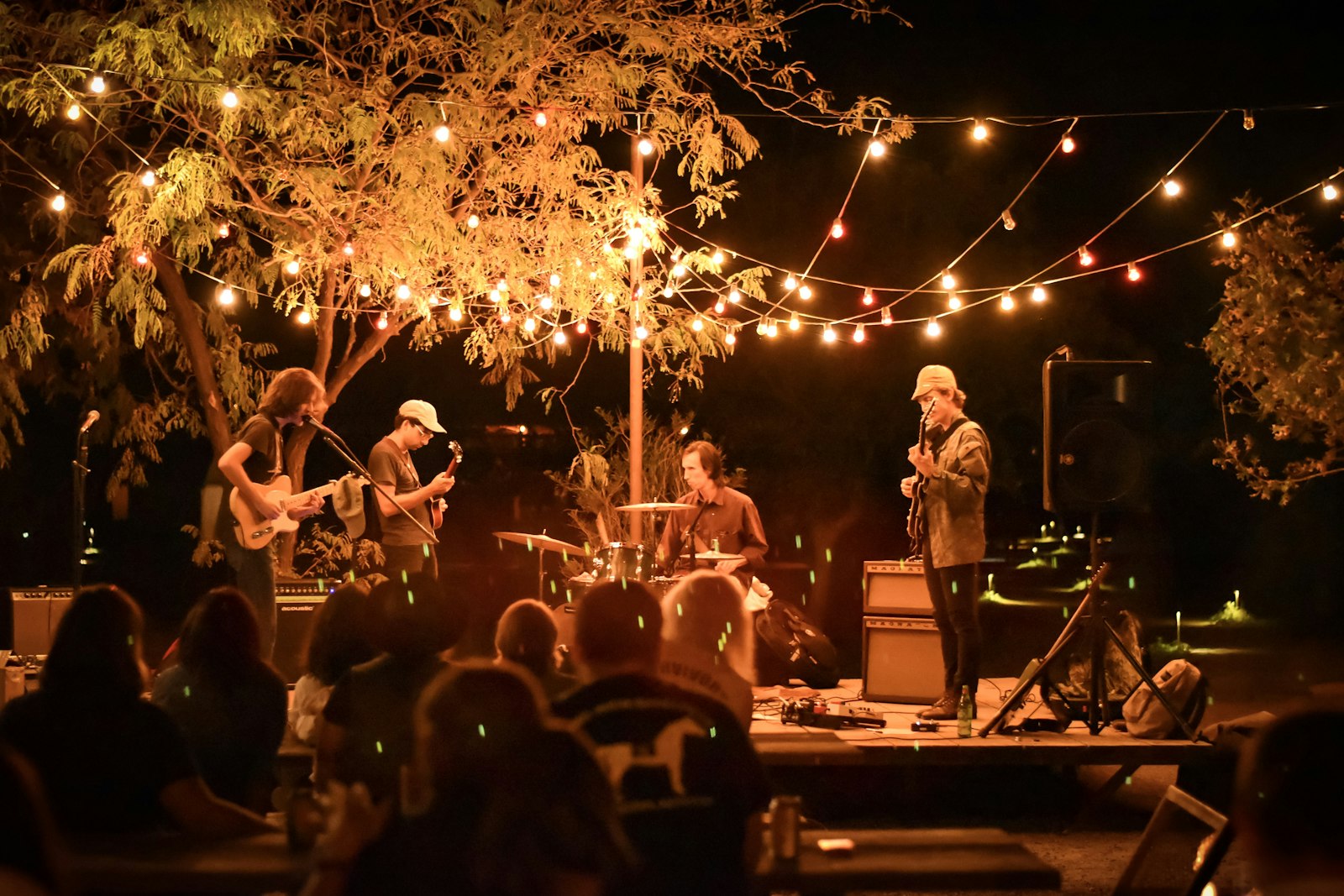 Feestelijk gedekte tafels en een klein podium voor een band op een bruiloft in de buitenlucht