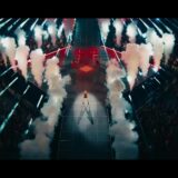 Taylor Swift op het podium tijdens The Eras Tour met rookzuilen aan weerszijden