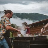 a group of people cooking on a grill outside