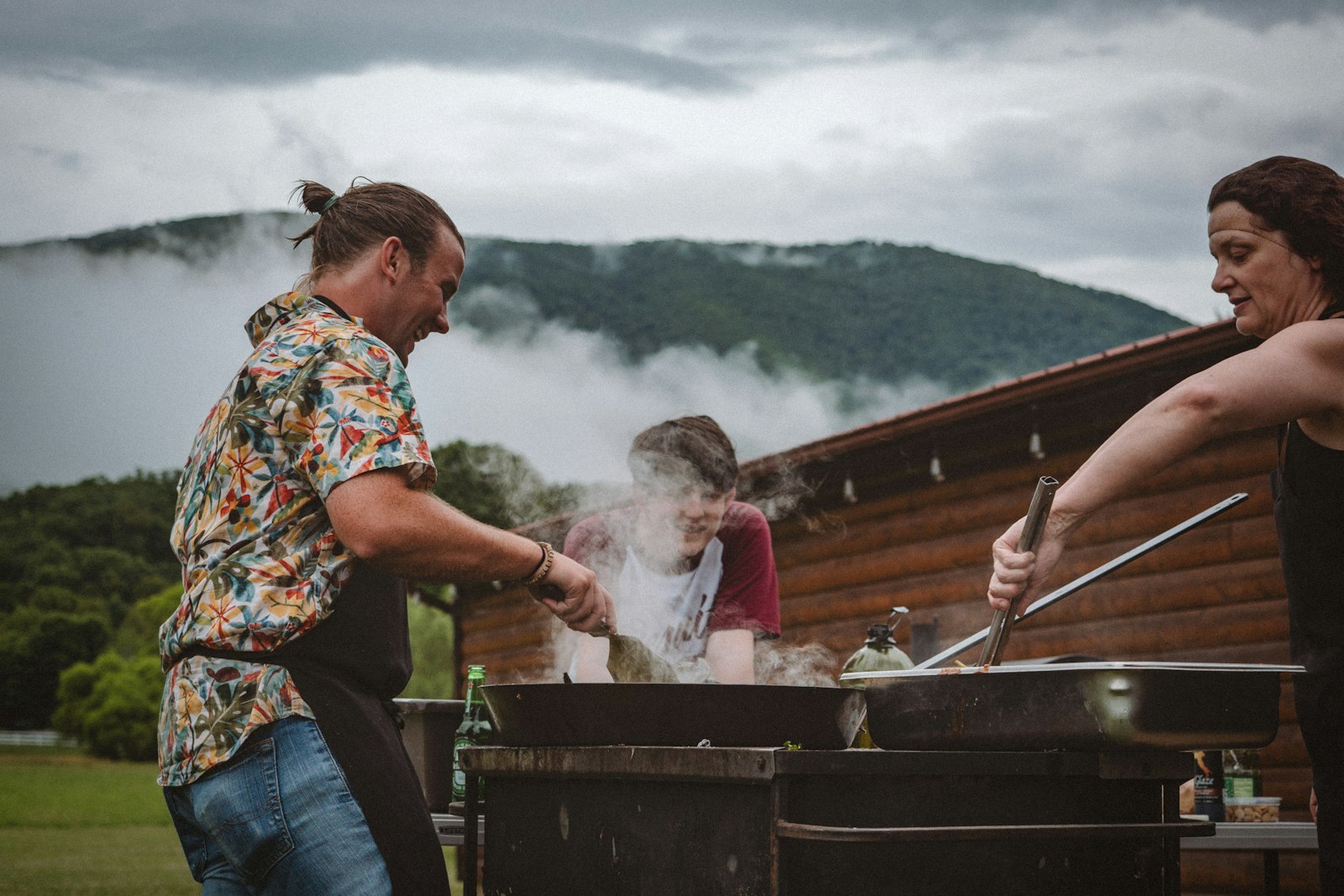 a group of people cooking on a grill outside