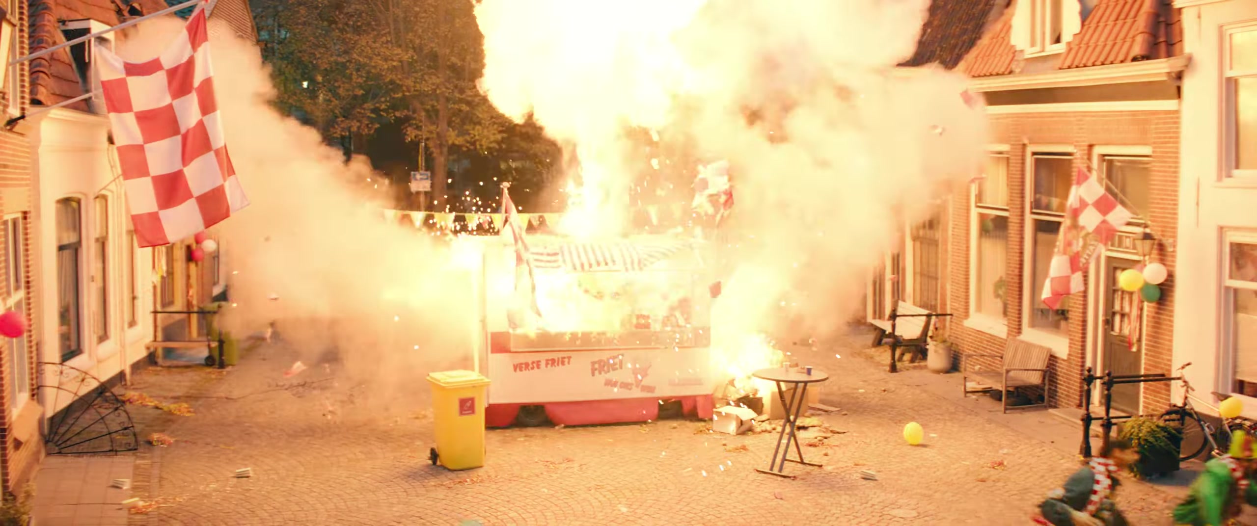 Explosie in een feestende straat vol carnavalsvlaggen in de film Carnaval