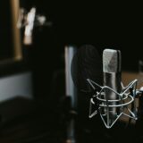 Twee microfoons op een tafel in een podcaststudio