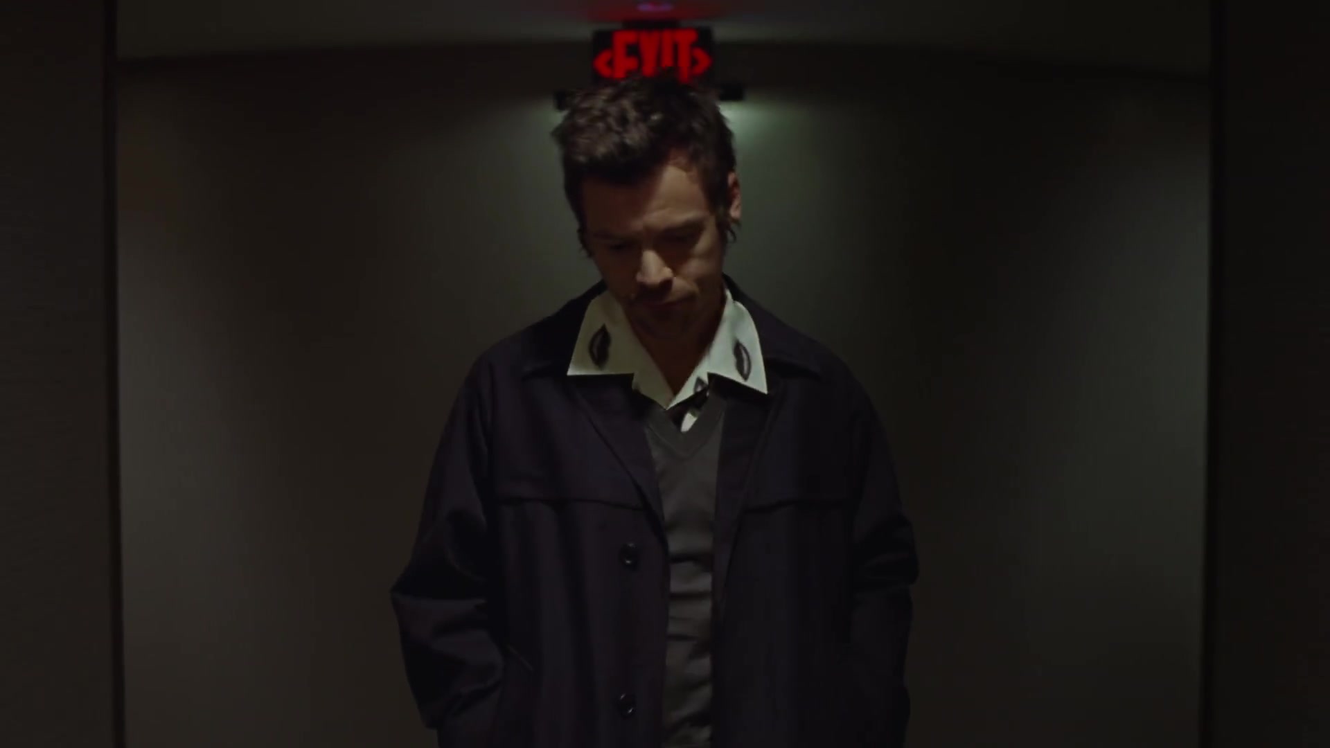 Harry Styles onder een rood exitbord in de officiële videoclip van Aperture