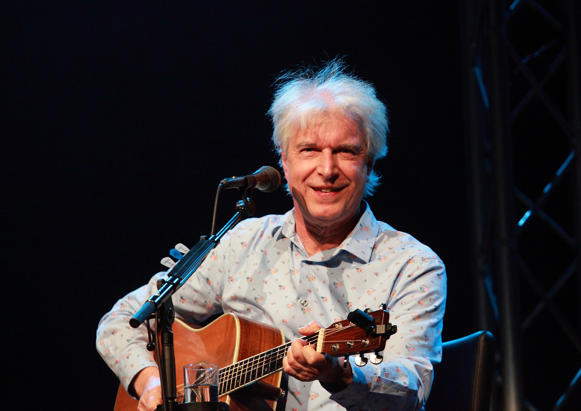 Boudewijn de Groot met akoestische gitaar op het podium in 2013