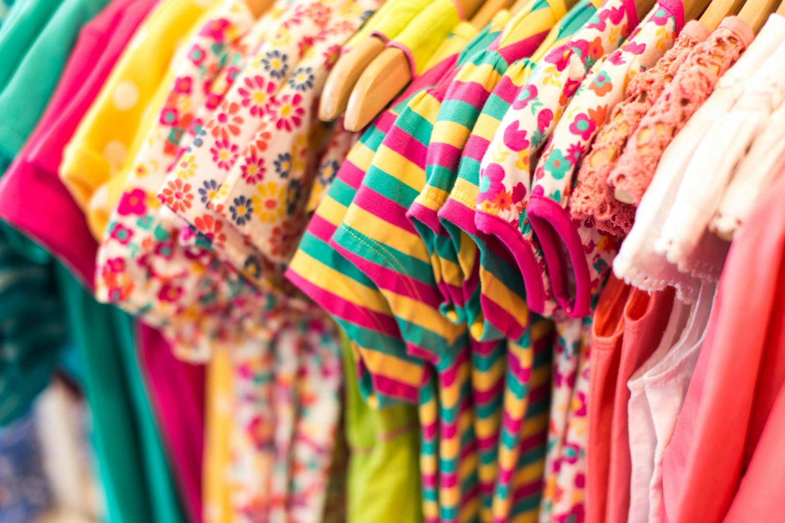 Kleurrijke kinderkleding aan hangers