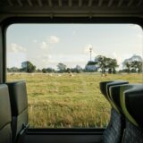 Uitzicht op weilanden vanuit een treinraam