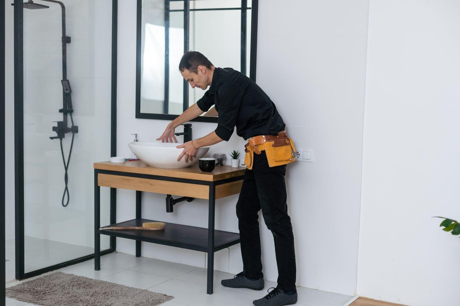 Vakman plaatst een waskom in een badkamer