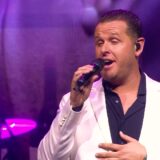 John West zingt in een wit jasje tijdens zijn concert in Ahoy in 2024