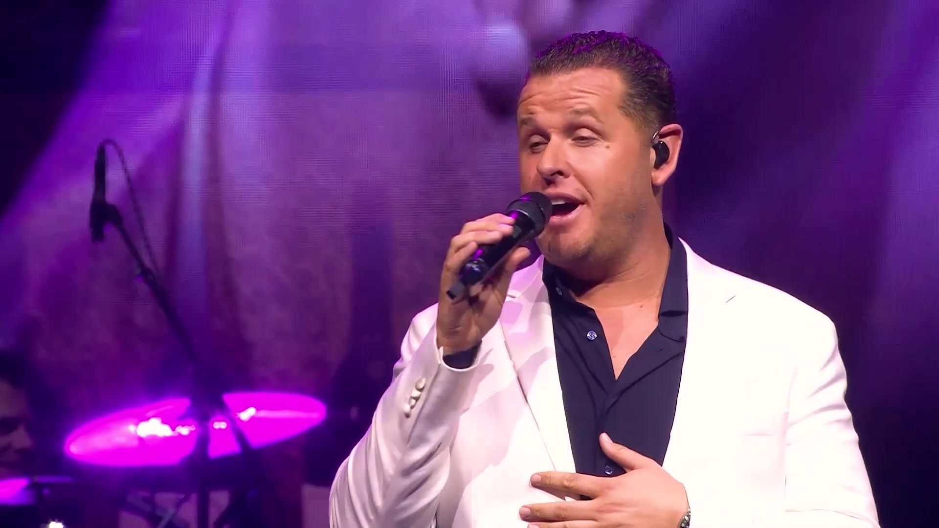 John West zingt in een wit jasje tijdens zijn concert in Ahoy in 2024