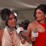 Kylie Jenner in een rode jurk naast Kim Kardashian bij het Met Gala in 2023