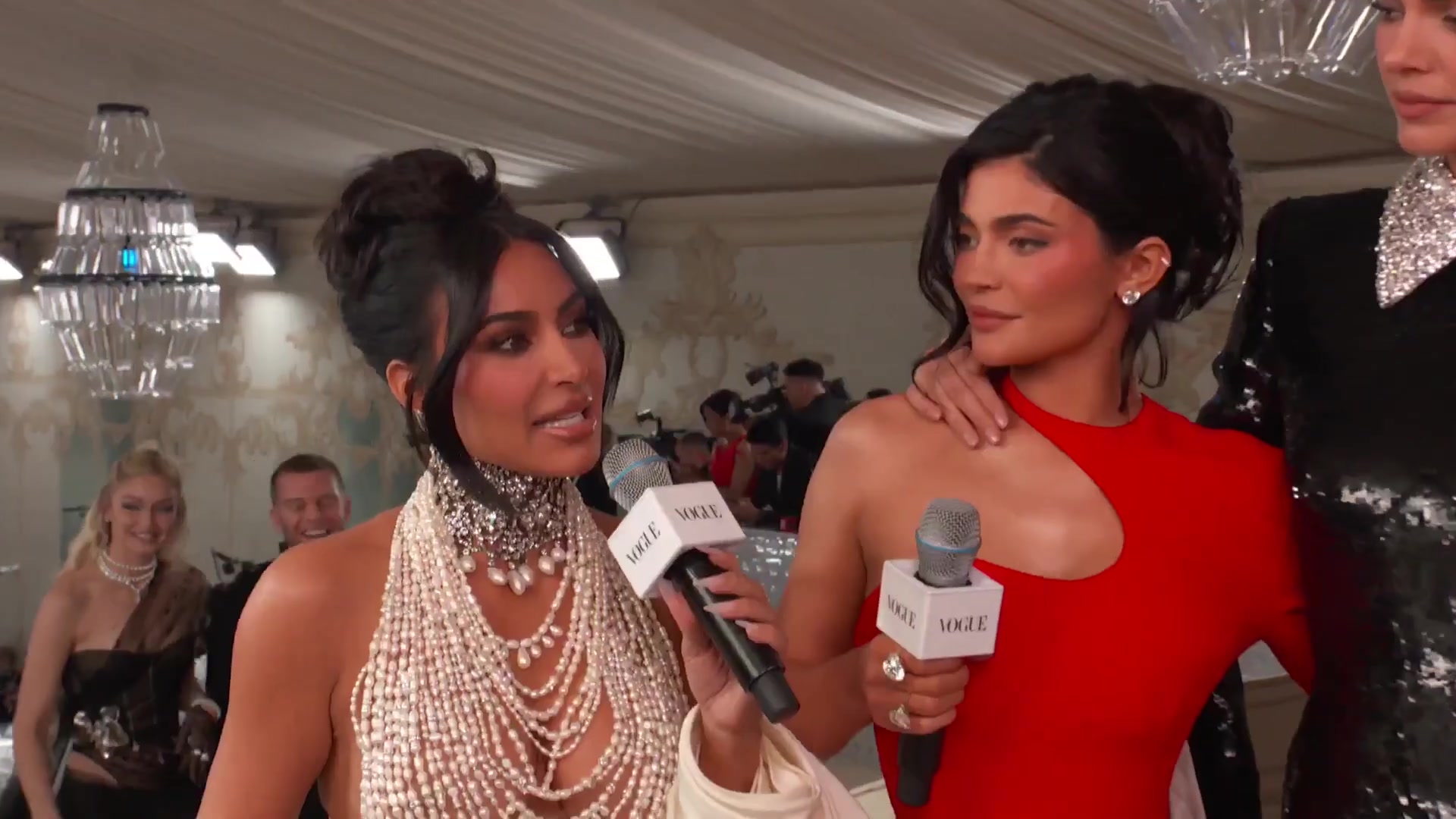 Kylie Jenner in een rode jurk naast Kim Kardashian bij het Met Gala in 2023