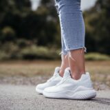 Vrouw loopt buiten op witte sneakers