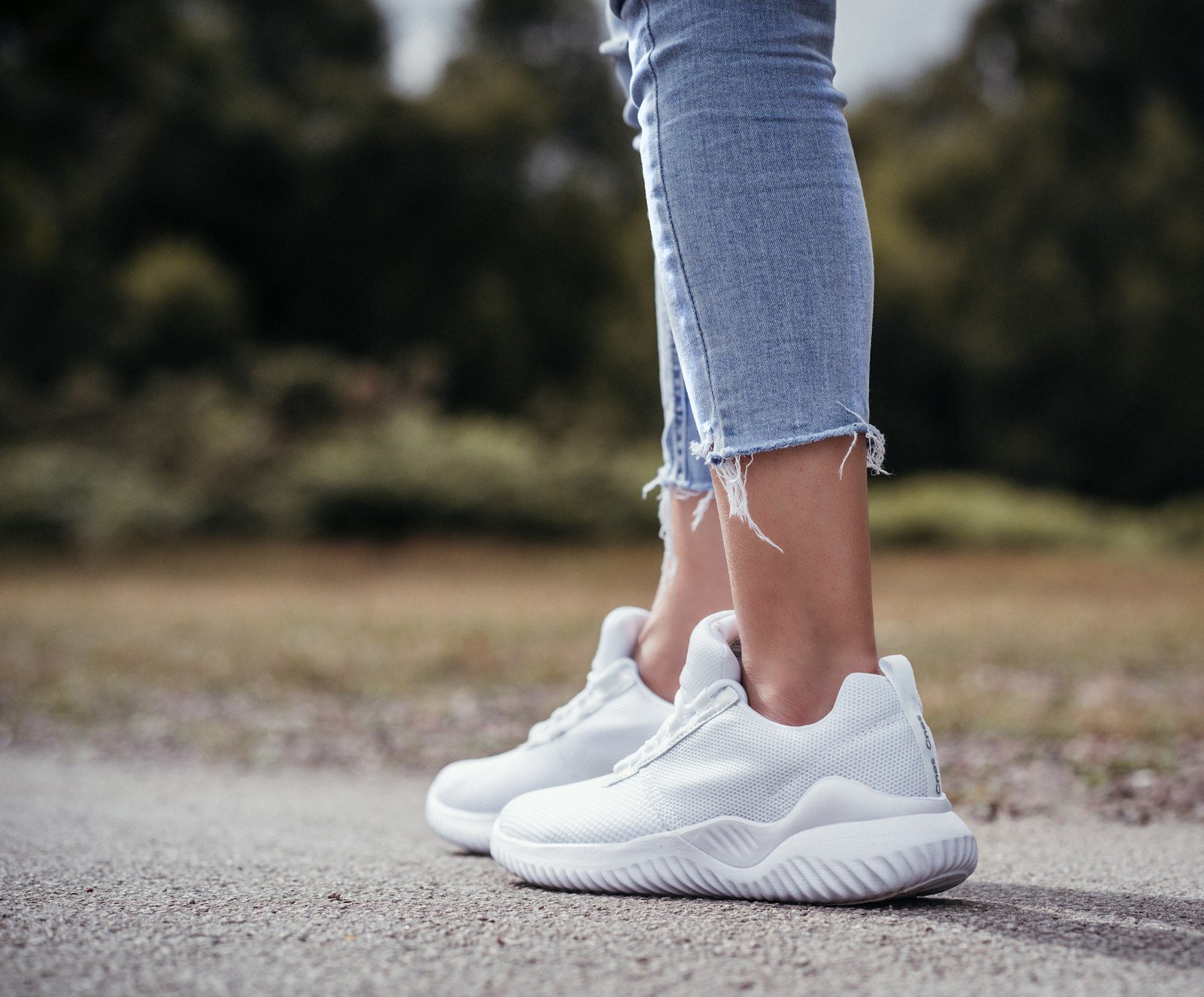Vrouw loopt buiten op witte sneakers