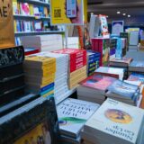 Een tafel met stapels boeken in een boekwinkel