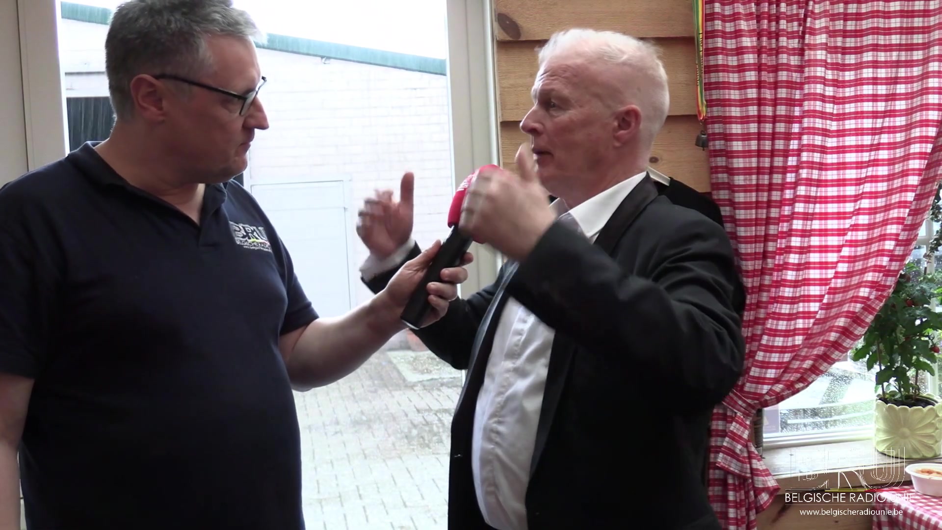 Peter Jan Rens in een zwart colbert tijdens een interview