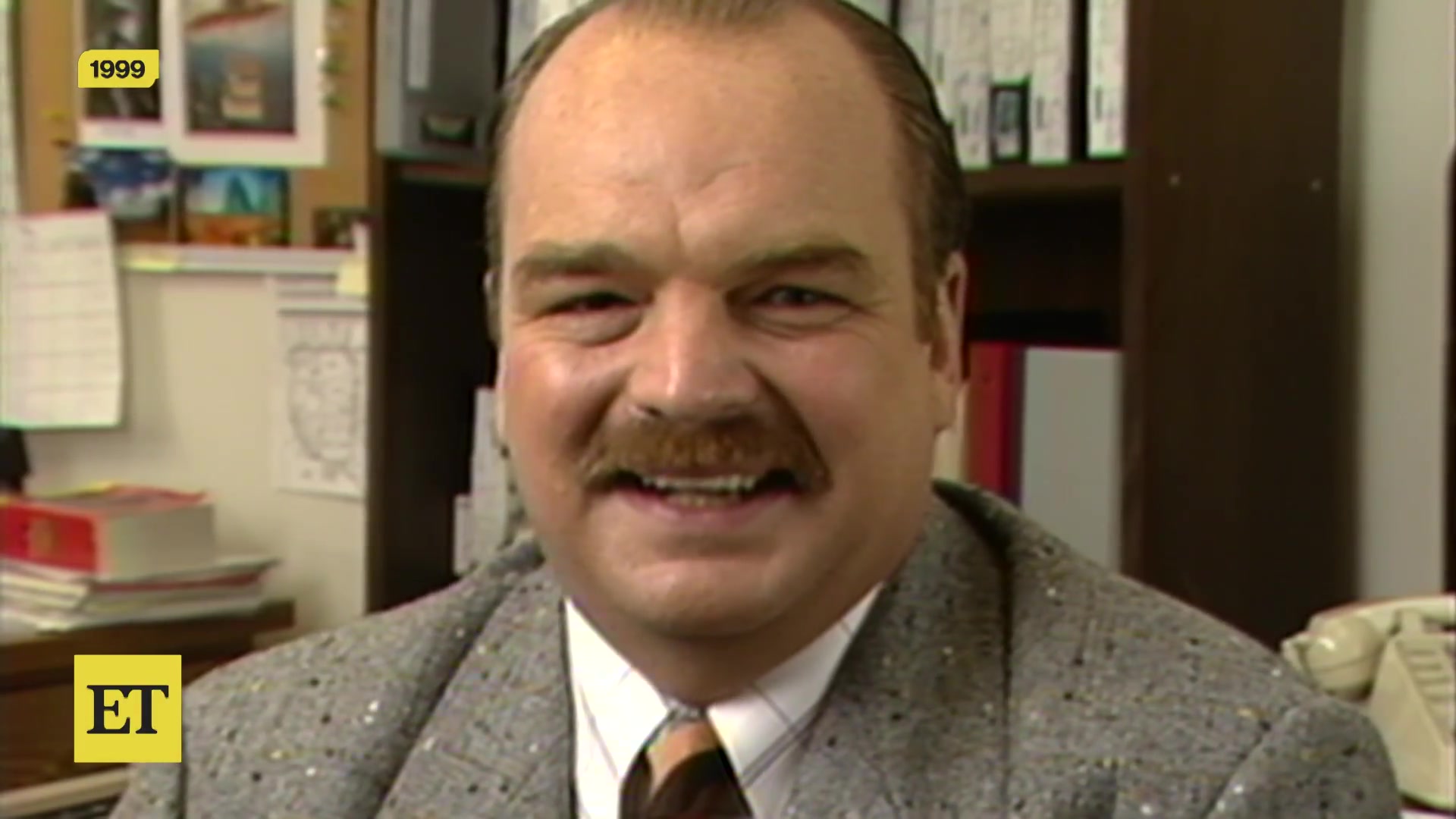 Acteur Richard Riehle met snor en grijs colbert in een interview uit 1999