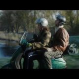 Scène uit de film Wen er maar aan met twee mensen op een scooter langs het water