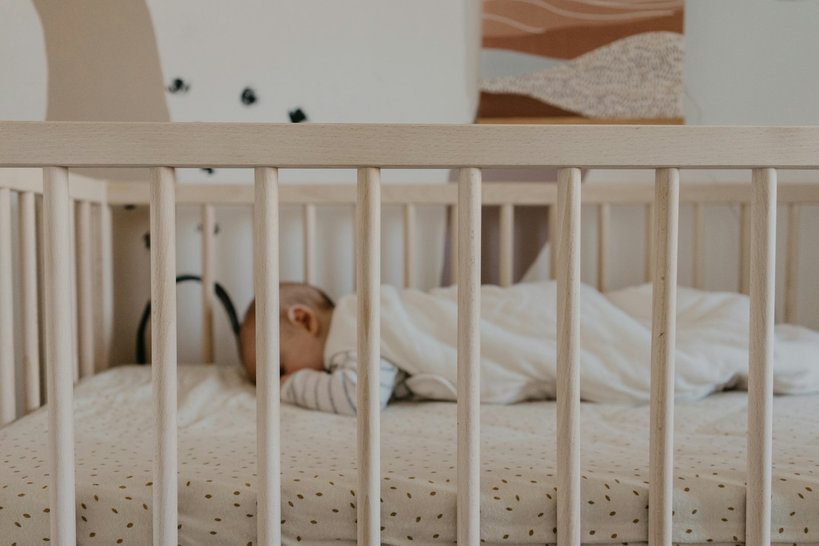 Babyslaapzak met rits in een ledikant
